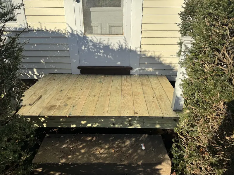 Newly rebuilt wooden entry stoop in fresh lumber